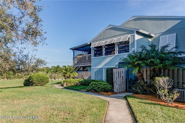 view of front of home with a front lawn and fence
