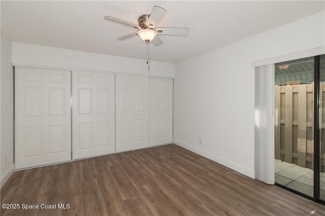 unfurnished bedroom featuring baseboards, wood finished floors, a closet, a textured ceiling, and a ceiling fan