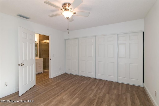 unfurnished bedroom with visible vents, ceiling fan, baseboards, wood finished floors, and a closet