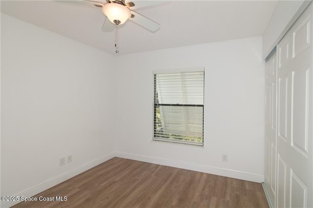 spare room featuring wood finished floors, baseboards, and ceiling fan