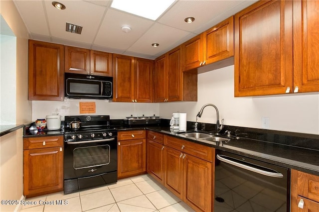 kitchen with brown cabinetry, black appliances, and a sink