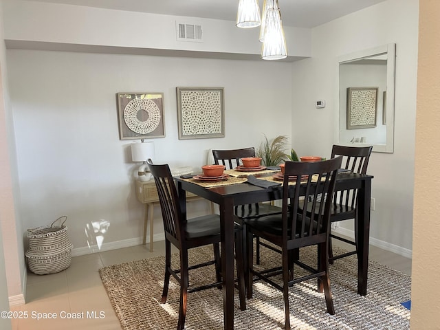tiled dining area with visible vents and baseboards