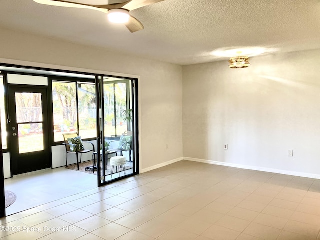 unfurnished room with baseboards, ceiling fan, and a textured ceiling