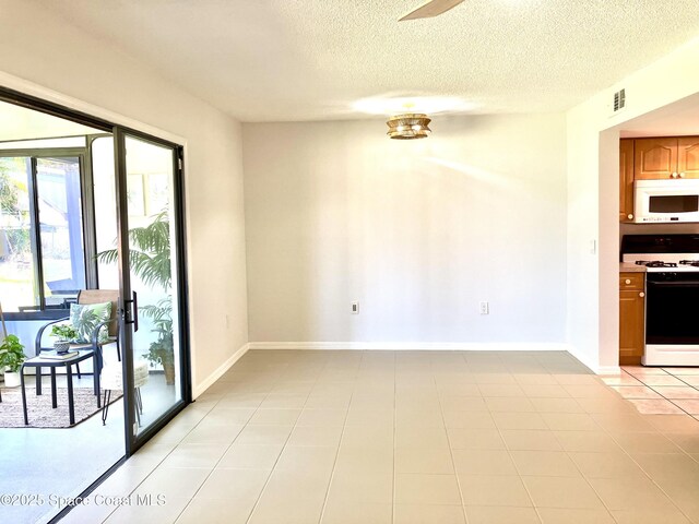 interior space with a textured ceiling, visible vents, ceiling fan, and baseboards