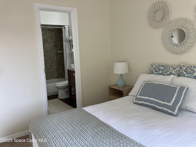 bedroom featuring baseboards and ensuite bathroom