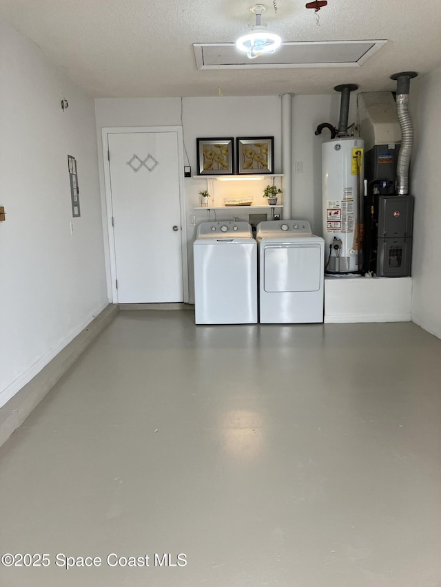 laundry room featuring a textured ceiling, washing machine and dryer, gas water heater, attic access, and laundry area