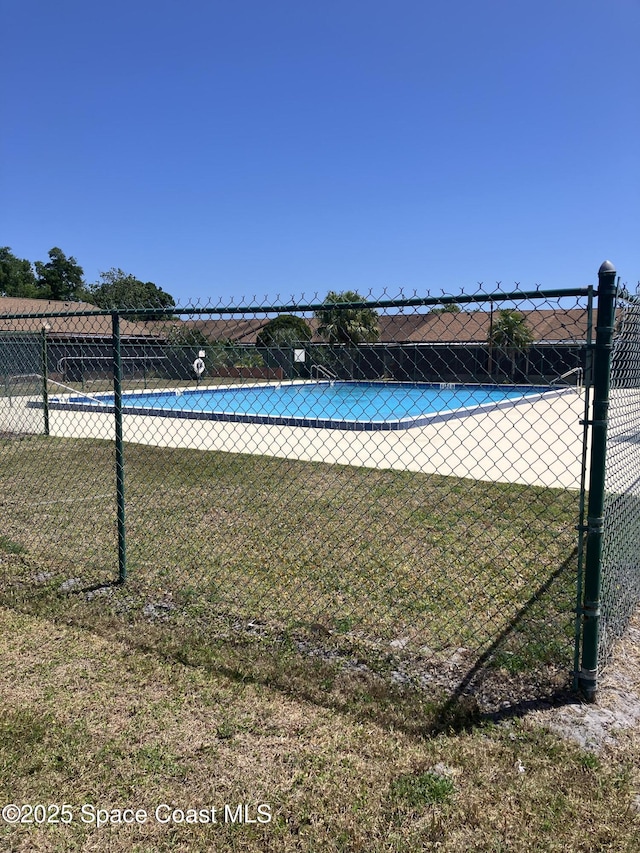 pool with fence and a yard