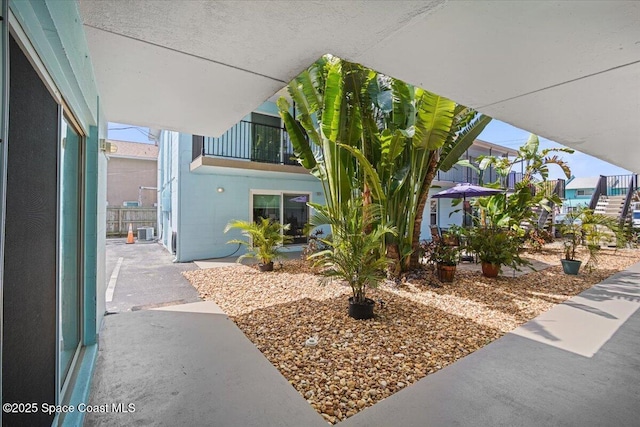 view of front of property with a patio area, concrete block siding, and central AC unit