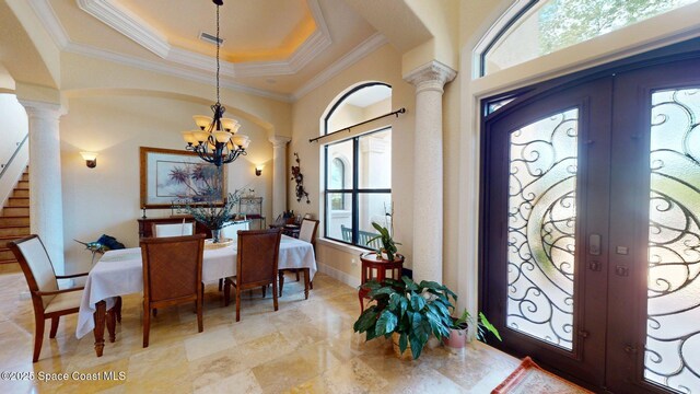 5454 Riveredge Dr, Titusville, FL 32780 - foyer with decorative columns, a chandelier, a tray ceiling, french doors, and ornamental molding