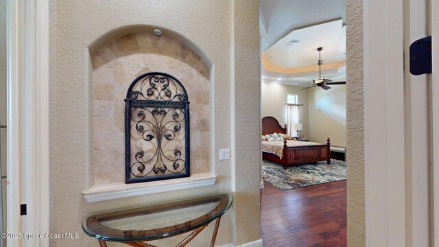 5454 Riveredge Dr, Titusville, FL 32780 - detailed view of a textured wall, wood finished floors, crown molding, a ceiling fan, and a tray ceiling