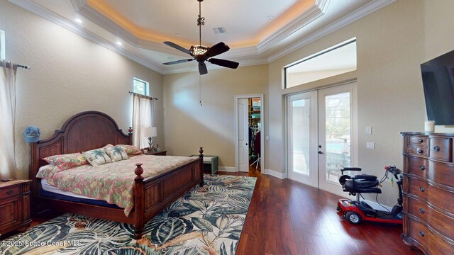 5454 Riveredge Dr, Titusville, FL 32780 - bedroom with french doors, dark wood finished floors, a tray ceiling, ornamental molding, and access to exterior