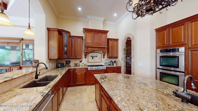 5454 Riveredge Dr, Titusville, FL 32780 - kitchen featuring stainless steel appliances, a sink, ornamental molding, light stone counters, and decorative light fixtures