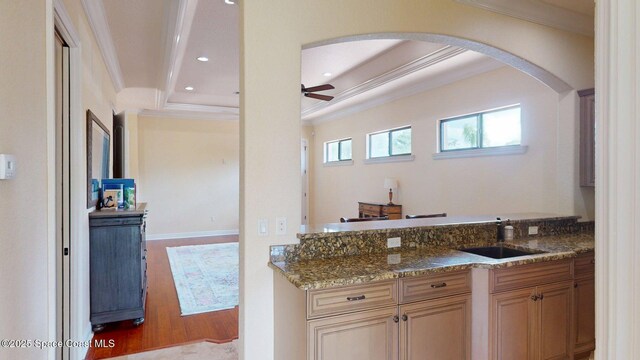 5454 Riveredge Dr, Titusville, FL 32780 - kitchen featuring ornamental molding, a sink, wood finished floors, a ceiling fan, and arched walkways