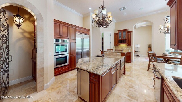5454 Riveredge Dr, Titusville, FL 32780 - kitchen featuring a chandelier, stainless steel appliances, a sink, arched walkways, and ornamental molding