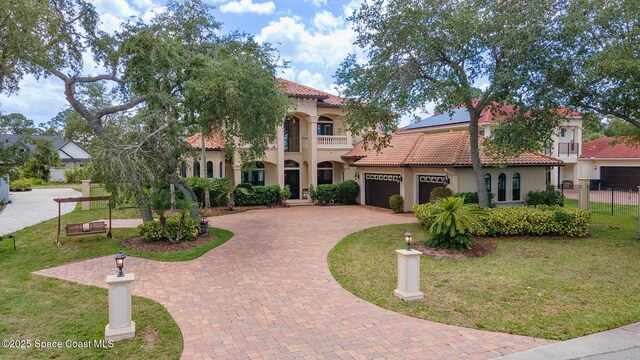 5454 Riveredge Dr, Titusville, FL 32780 - mediterranean / spanish-style home with decorative driveway, a tiled roof, stucco siding, and a garage