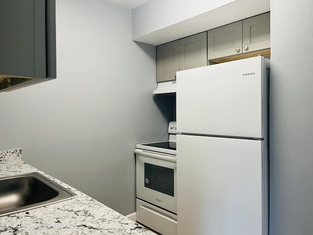kitchen with white appliances, light countertops, under cabinet range hood, and gray cabinetry