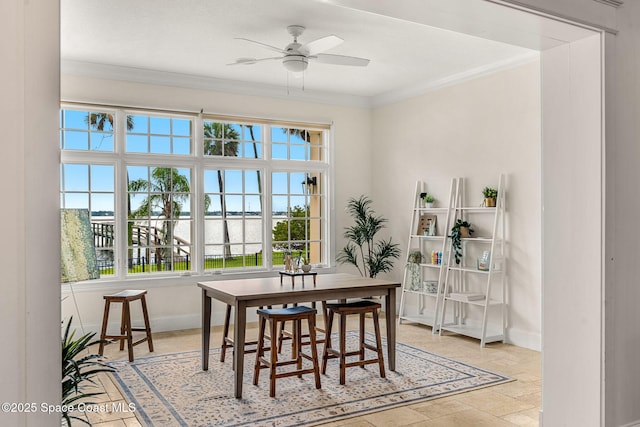 7021 S Tropical Trl, Merritt Island, FL 32952 - dining space with ceiling fan, crown molding, baseboards, a water view, and light stone finish floors
