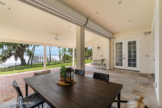 7021 S Tropical Trl, Merritt Island, FL 32952 - view of patio / terrace with french doors, a water view, outdoor dining space, and ceiling fan