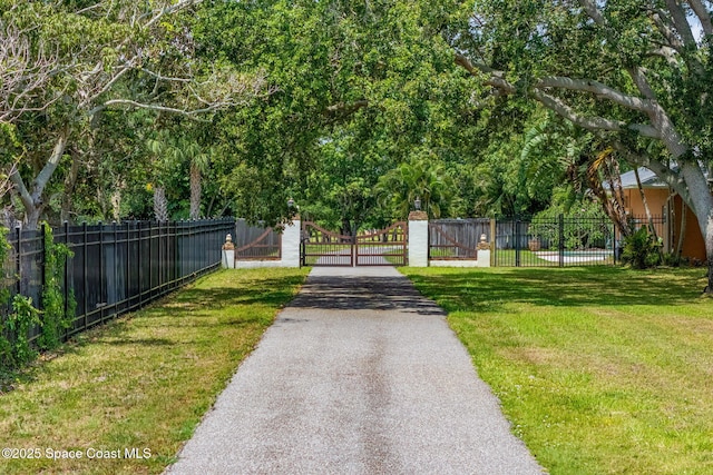 7021 S Tropical Trl, Merritt Island, FL 32952 - view of home's community featuring a gate and asphalt driveway
