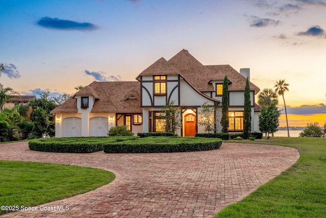 7021 S Tropical Trl, Merritt Island, FL 32952 - tudor home featuring stucco siding, curved driveway, and a yard