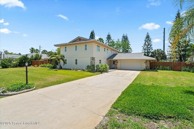 view of front of home with concrete driveway, stucco siding, a front yard, fence, and a garage