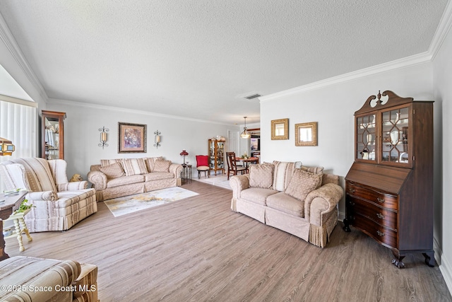 445 Park Ave, Satellite Beach, FL 32937 - living area with a textured ceiling, light wood-style flooring, crown molding, and a chandelier