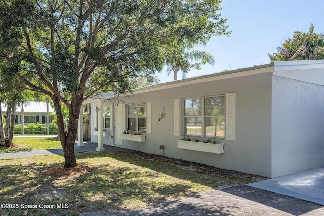 view of front of property with stucco siding and a front lawn