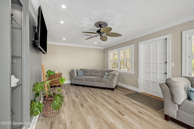 living area with a textured ceiling, light wood-style floors, a ceiling fan, and ornamental molding