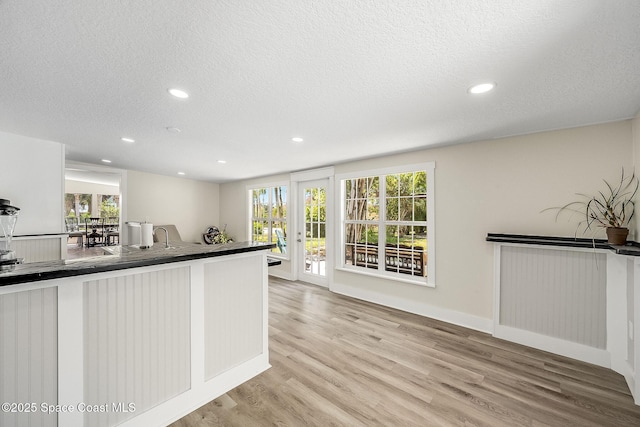 kitchen featuring dark countertops, recessed lighting, light wood-style floors, and a textured ceiling