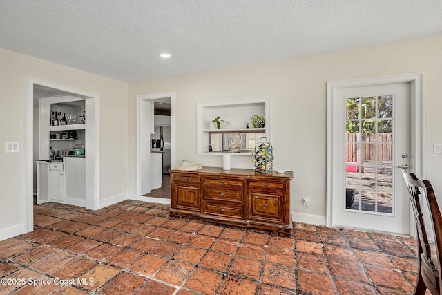 interior space with recessed lighting, baseboards, and a textured ceiling