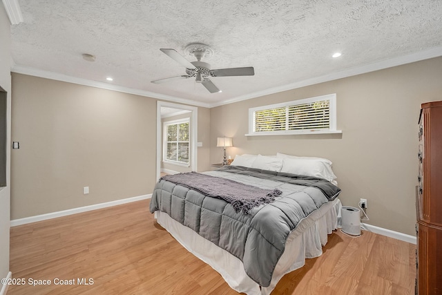 bedroom featuring baseboards, multiple windows, ornamental molding, and light wood finished floors