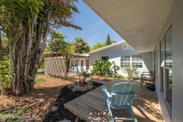 wooden deck with a pergola and a patio