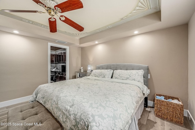 bedroom with visible vents, a walk in closet, baseboards, and wood finished floors