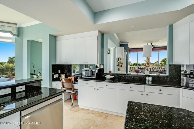 601 N Swim Club Dr Pha, Pha, Indian River Shores, FL 32963 - kitchen with white cabinetry, decorative backsplash, dark stone countertops, and stainless steel microwave