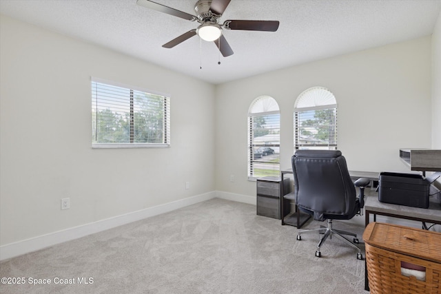 home office featuring baseboards, carpet floors, a wealth of natural light, and a textured ceiling