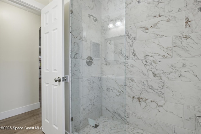 full bathroom with baseboards, wood finished floors, and a shower stall