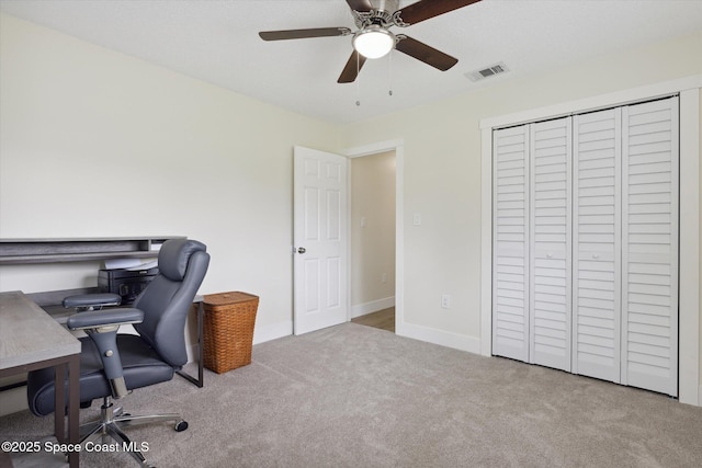 carpeted office featuring baseboards, ceiling fan, and visible vents