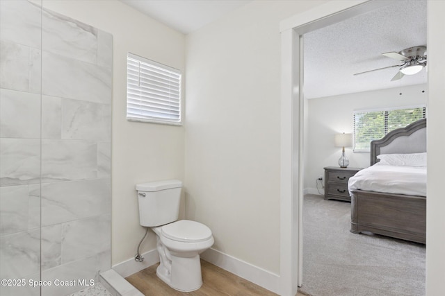 ensuite bathroom featuring connected bathroom, toilet, a ceiling fan, a textured ceiling, and baseboards
