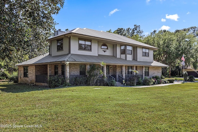 5425 James Ln, Mims, FL 32754 - view of front facade with a chimney, a front yard, a porch, and brick siding