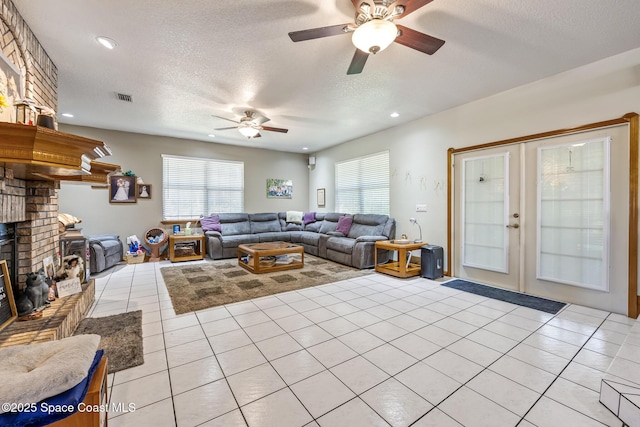 5425 James Ln, Mims, FL 32754 - living area with visible vents, a brick fireplace, a ceiling fan, french doors, and light tile patterned floors