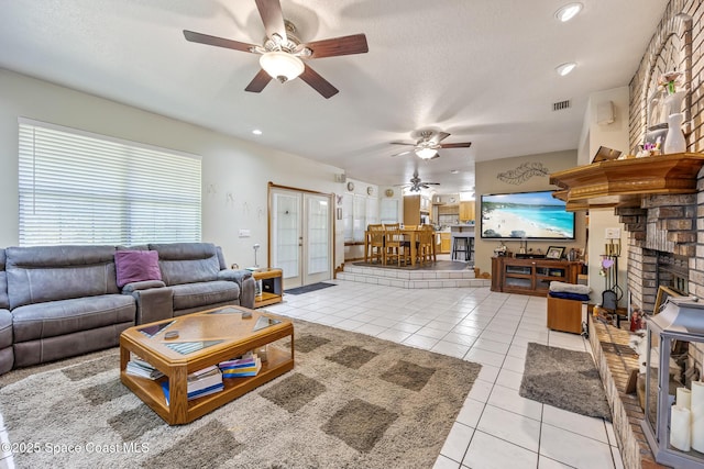 5425 James Ln, Mims, FL 32754 - living area with light tile patterned flooring, a fireplace, a textured ceiling, visible vents, and ceiling fan