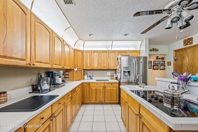 5425 James Ln, Mims, FL 32754 - kitchen with black electric cooktop, stainless steel refrigerator with ice dispenser, light tile patterned floors, a textured ceiling, and a ceiling fan