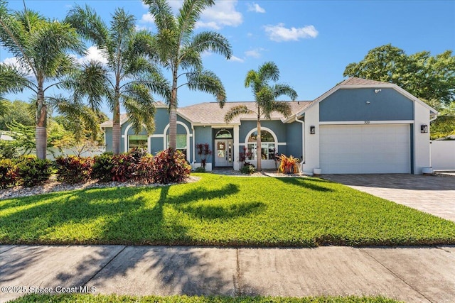 view of front of home featuring a front yard, decorative driveway, stucco siding, and an attached garage
