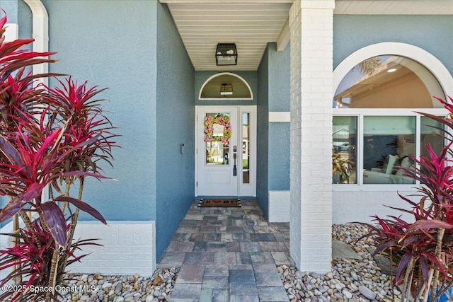 property entrance with stucco siding
