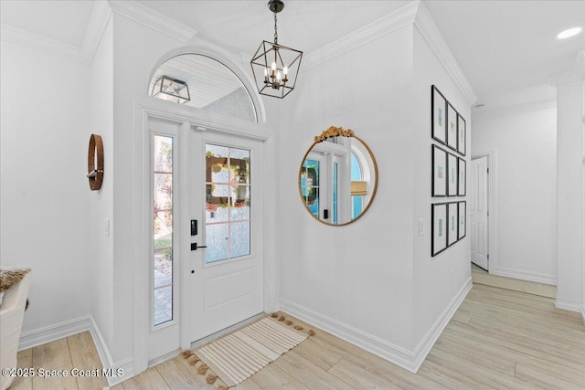 entryway featuring light wood-type flooring, crown molding, and a chandelier