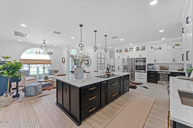 kitchen with white cabinetry, visible vents, dark cabinets, and appliances with stainless steel finishes