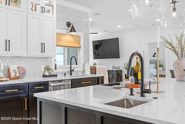 kitchen with white cabinets, ornamental molding, a sink, light stone counters, and stainless steel dishwasher