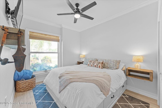 bedroom with crown molding, baseboards, ceiling fan, and wood finished floors
