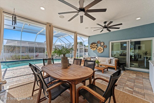 sunroom featuring an outdoor hangout area, ceiling fan, and a swimming pool