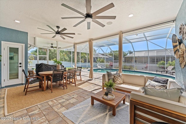 sunroom featuring a swimming pool, a ceiling fan, outdoor lounge area, and outdoor dining space